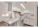 Bright kitchen with white cabinetry, appliances, and a breakfast bar area at 12221 W Bell Rd # 249, Surprise, AZ 85378