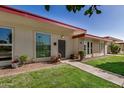 Lovely home with red trim, decorative plantings, and green lawns at 13009 N 100Th Dr, Sun City, AZ 85351