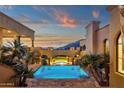Desert property showcasing a luxury swimming pool, spa, lush landscaping and an inviting sunset view at 14675 E Paradise Dr, Fountain Hills, AZ 85268