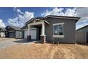 Side view of single-story home featuring two-car garage and low maintenance landscaping at 15769 W Beryl Ave, Waddell, AZ 85355