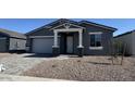 Charming single-story home featuring a gray exterior, stone accents, and a well-manicured front yard at 15769 W Beryl Ave, Waddell, AZ 85355