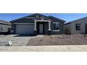Charming single-story home featuring a gray exterior, stone accents, and a well-manicured front yard at 15769 W Beryl Ave, Waddell, AZ 85355