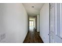 Bright hallway with wood-look flooring leading to an open living area with sliding glass doors at 15769 W Beryl Ave, Waddell, AZ 85355