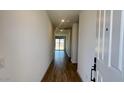 Inviting hallway with wood floors leading to a bright living area and sliding glass doors at 15769 W Beryl Ave, Waddell, AZ 85355