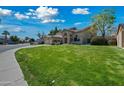 A landscaped front yard with a well-maintained lawn and a three car garage adds to the curb appeal at 16018 N 17Th Way, Phoenix, AZ 85022