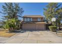 Charming two-story home with a two-car garage, lush trees, and a basketball hoop in the driveway at 18194 N 59Th Ln, Glendale, AZ 85308