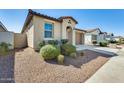 Well-manicured front yard with lush landscaping, a two-car garage, and a charming entrance at 19685 W Roma Ave, Litchfield Park, AZ 85340