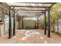 Charming outdoor patio with a pergola, offering a cozy space for relaxation and entertaining amidst lush greenery at 2048 W Elm St, Phoenix, AZ 85015