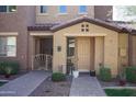 Charming townhome entrance featuring a tan facade, decorative gate, and neat landscaping at 250 W Queen Creek Rd # 229, Chandler, AZ 85248