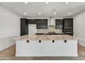 Modern kitchen with a large island, granite countertops, stainless steel appliances, and dark cabinets at 31783 N 130Th Ave, Peoria, AZ 85383