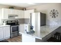 Bright kitchen with stainless steel appliances, granite countertops, and white cabinets at 419 E Gemini Dr, Tempe, AZ 85283