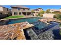 Stunning backyard pool and spa featuring custom stone work and a well-manicured lawn, perfect for outdoor entertaining at 42209 N 46Th Ln, Phoenix, AZ 85086