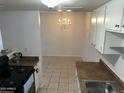 Eat-in kitchen with appliances, tiled floors, and a chandelier at 4650 E Wood St, Phoenix, AZ 85040