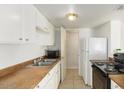 Functional kitchen with white cabinetry, laminate countertops, and essential appliances at 4650 E Wood St, Phoenix, AZ 85040