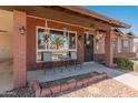 Inviting front porch featuring a seating area and decorative hanging planters at 8540 N 104Th Ave, Peoria, AZ 85345