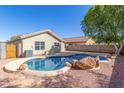 Backyard pool view from home, showcasing rock features and updated landscaping at 11359 E Elena Ave, Mesa, AZ 85208