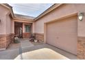 Close up exterior view of a tan stucco home with a two car garage on the right at 1629 E Prickly Pear Pl, Casa Grande, AZ 85122