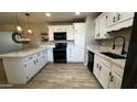 Updated kitchen showcases white cabinets, black appliances, modern countertops, and stylish pendant lighting at 1803 W 6Th St, Mesa, AZ 85201
