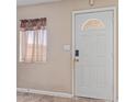 Entryway with a white front door with glass insert and security features at 207 E Cedar Ave, Casa Grande, AZ 85122