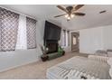 Living room with large TV, fireplace, and ceiling fan at 207 E Cedar Ave, Casa Grande, AZ 85122
