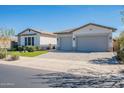 Charming single-story home with a two-car garage, beautiful landscaping, and a well-maintained front yard at 25751 S 227Th Way, Queen Creek, AZ 85142