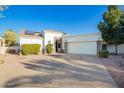 Attractive front of home with driveway, desert landscaping, lawn, and two car garage at 3019 E Redfield Rd, Phoenix, AZ 85032