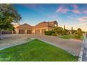 Spacious four-car garage with a brick driveway, surrounded by lush landscaping and well-maintained greenery at 3446 E Knoll St, Mesa, AZ 85213