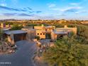 Scenic aerial view of a modern desert home with lush landscaping near a golf course and other residences at 39877 N 107Th Way, Scottsdale, AZ 85262