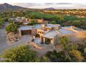 Expansive aerial view of a stunning home nestled in a picturesque desert landscape near a golf course and mountains at 39877 N 107Th Way, Scottsdale, AZ 85262