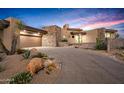 Charming desert home with modern architecture, a stone accent wall, and desert landscaping in the front yard at 39877 N 107Th Way, Scottsdale, AZ 85262