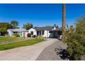A lovely home boasts a verdant lawn and a convenient carport for shaded parking at 406 W Coolidge St, Phoenix, AZ 85013
