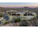 Sprawling modern home boasts stone facade, mature landscaping, a circular driveway, and desert views at 42690 N 98Th Pl, Scottsdale, AZ 85262