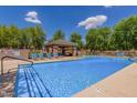 Community pool with clear blue water and several chairs for lounging at 4354 E Rosemonte Dr, Phoenix, AZ 85050