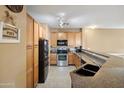 Well-lit kitchen featuring wooden cabinets, stainless steel appliances and countertop seating at 4769 E Thunderheart Trl # 101, Gilbert, AZ 85297