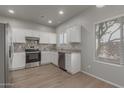 Modern kitchen with white cabinets, stainless steel appliances, and granite countertops and backsplash at 625 N Hamilton St # 36, Chandler, AZ 85225