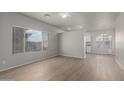Open-concept living room featuring wood floors, large windows, and a view into the kitchen and dining area at 625 N Hamilton St # 36, Chandler, AZ 85225