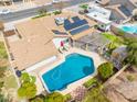 Aerial view of the backyard featuring a pool, solar panels, patio with pergola, and landscaped yard at 6409 W Riviera Dr, Glendale, AZ 85304