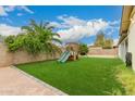 A wood playset sits on grass in this spacious backyard at 7605 W Avalon Dr, Phoenix, AZ 85033