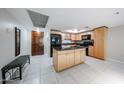 Spacious kitchen with a large island, black appliances, and light wood cabinets at 7860 E Camelback Rd # 309, Scottsdale, AZ 85251