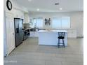 Bright kitchen featuring white cabinetry, stainless steel appliances, island and tile floors at 8837 W Coolidge St, Phoenix, AZ 85037