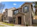 Well-kept townhome featuring a decorative brick entryway, shutters, and neutral stucco facade at 9233 E Neville Ave # 1138, Mesa, AZ 85209