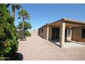 Cozy backyard with a covered patio, gravel landscaping, and privacy trees at 9763 W Butler Dr, Peoria, AZ 85345