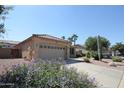 Charming single-story home featuring desert landscaping with gravel and flowering bushes at 9763 W Butler Dr, Peoria, AZ 85345