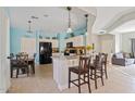 Bright kitchen with a breakfast bar, granite countertops, and a view into dining and living areas at 10718 E Secret Canyon Rd, Gold Canyon, AZ 85118