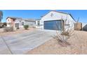 Charming single-story home with a blue garage door, long driveway, and desert landscaping at 11310 E Wallflower Ln, Florence, AZ 85132