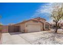 View of single-story home with two-car garage, xeriscaped front yard and privacy gate on long driveway at 14105 N 157Th Ct, Surprise, AZ 85379