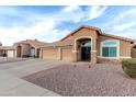 Charming single-story home featuring a three-car garage, low maintenance desert landscaping, and classic Southwestern architecture at 1412 E Erie St, Chandler, AZ 85225