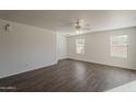 Well-lit living room featuring wood floors, ceiling fan, and dual pane windows for natural light at 1615 W Hidalgo Ave, Phoenix, AZ 85041