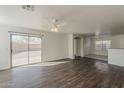 Bright and spacious living room featuring wood floors, ceiling fan, and sliding glass doors to the outdoor patio at 1615 W Hidalgo Ave, Phoenix, AZ 85041