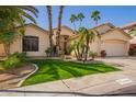 Inviting single-story home with a three-car garage, desert landscaping, and lush green lawn at 16608 N 51St St, Scottsdale, AZ 85254